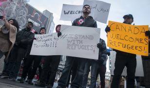 Protest with signs "Canada Welcomes Refugees"