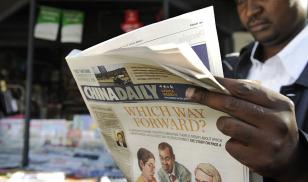 A newspaper consumer reads a copy of China's Africa edition of its daily newspaper infront of a news stand in the Kenyan capital on December 14, 2012. Photo credit:TONY KARUMBA/AFP via Getty Images.