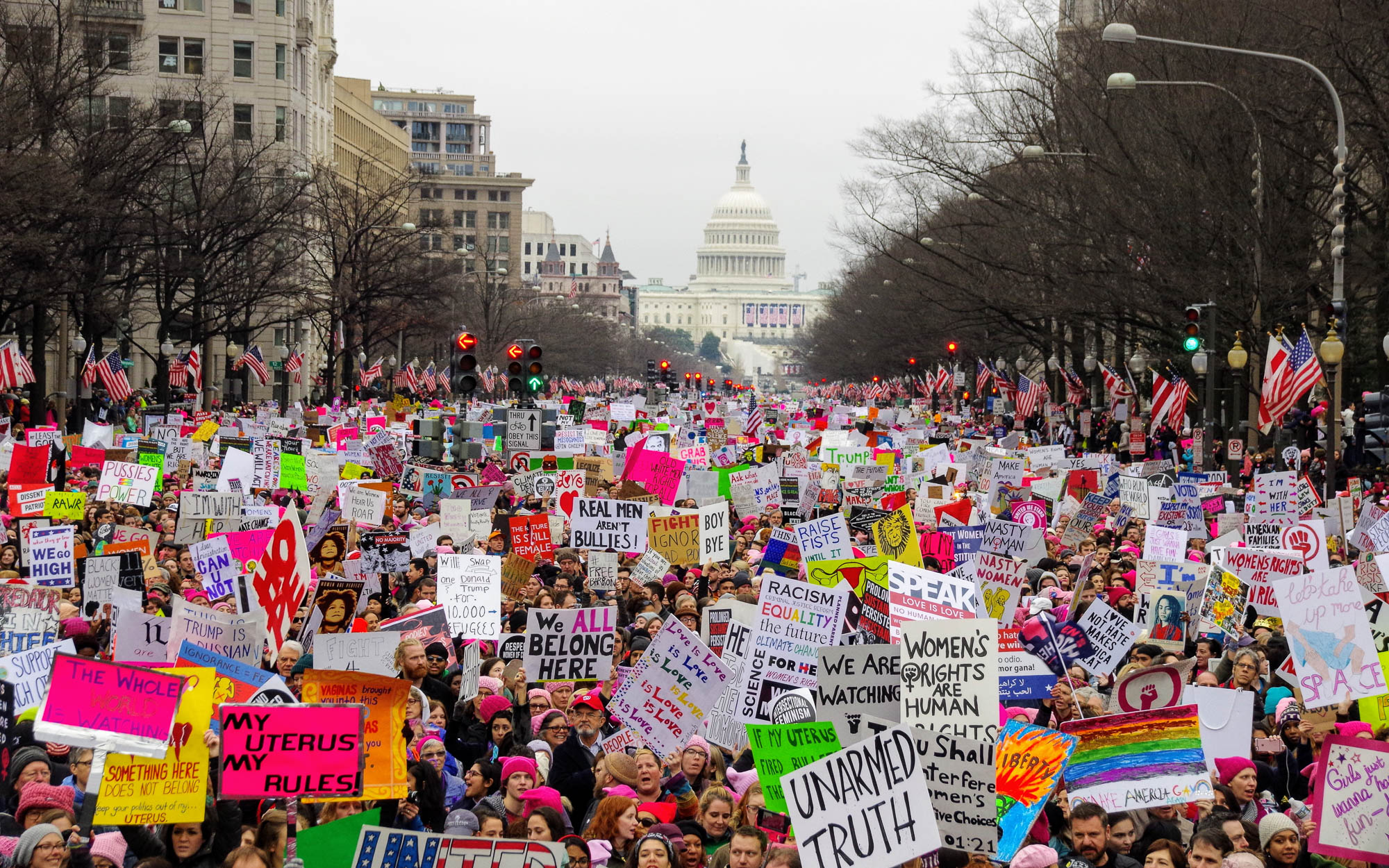 The 2017 women's march takes place in downtown Washington D.C. with the Trump Hotel and the Capitol Building in the background. Editorial credit: G. Midford / Shutterstock.com.