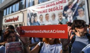  A journalist holds a banner on July 24, 2017 outside the headquarters of opposition daily newspaper Cumhuriyet in Istanbul. Editorial Credit:OZAN KOSE/AFP via Getty Images.
