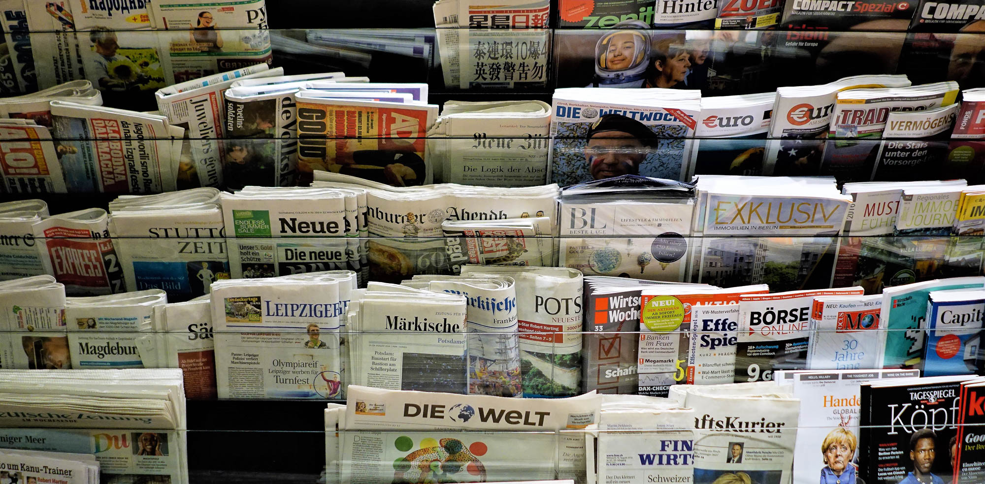 Berlin, Germany - August 2016: Colorful and interesting collection of european newspapers, periodicals, magazines in newsstand rack. Editorial credit: P Gregory / Shutterstock.com.