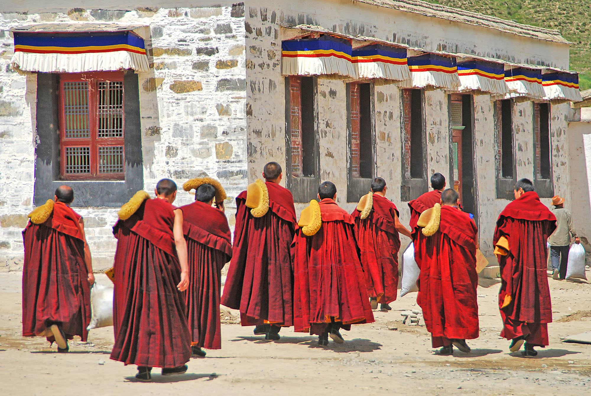 Tibetan monks outside the Labrang Monastery in Tibet. Editorial Credit: Editorial credit: Marcin Szymczak / Shutterstock.com.
