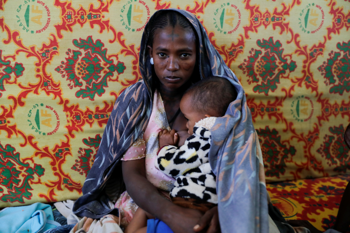 A woman holds an infant inside the Adiha secondary school, which was turned into a temporary shelter for people displaced by conflict, in the city of Mekelle, Tigray region, Ethiopia